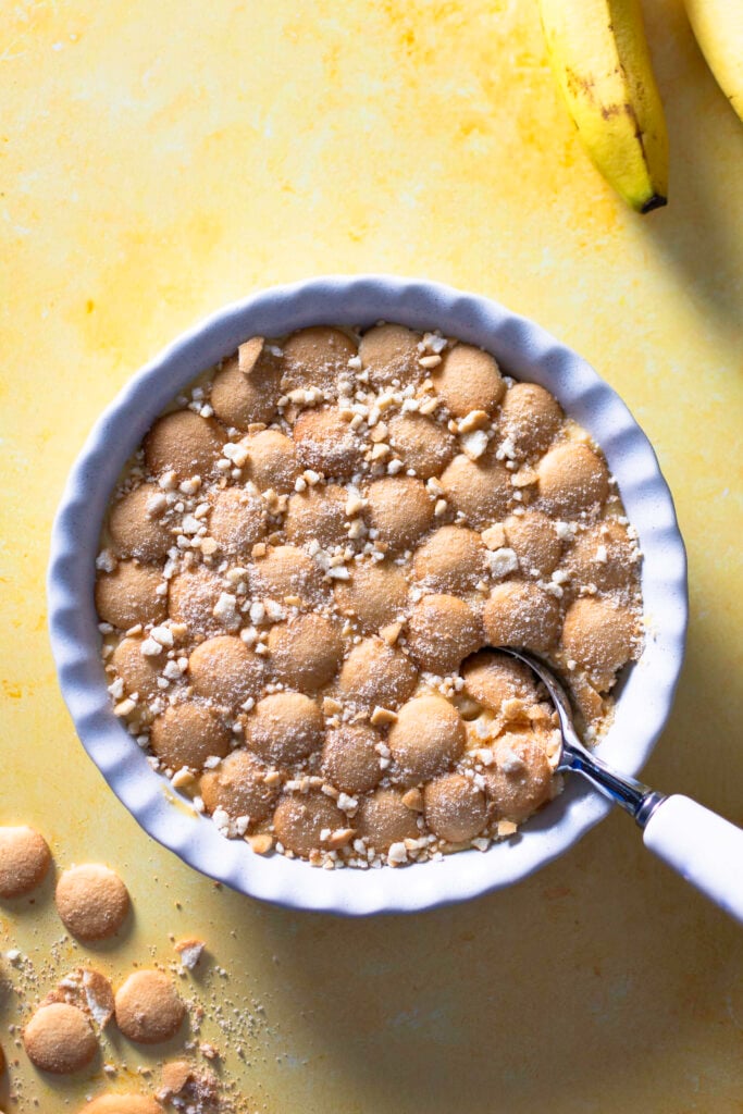 classic banana pudding topped with Nilla wafers being scooped
