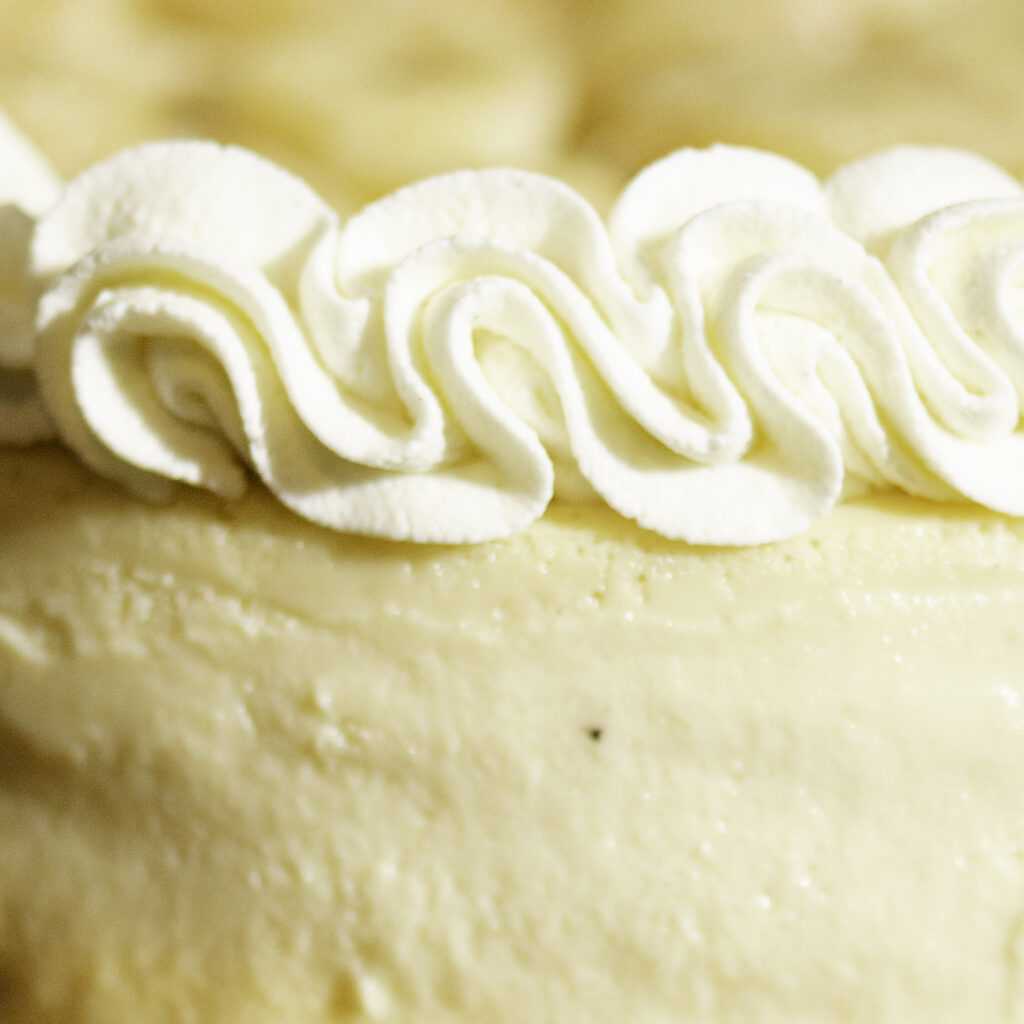 stabilized whipped cream border around top of cheesecake