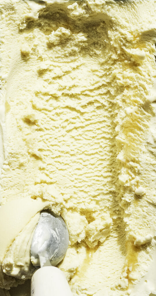 closeup of a container of salted maple ice cream being scooped
