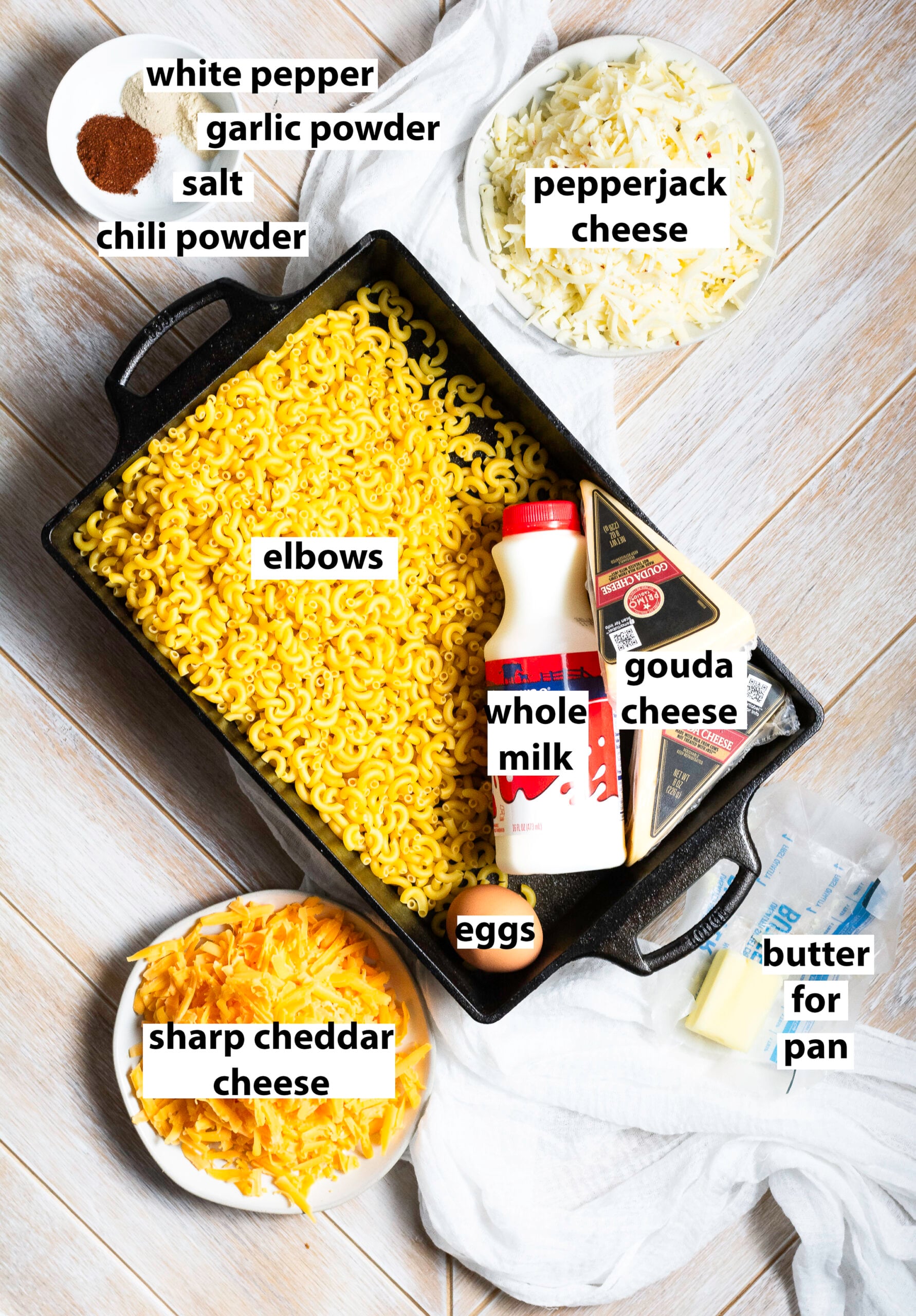 ingredients for old-fashioned mac and cheese - whole milk, salt, white pepper, chili powder, garlic powder, sharp cheddar cheese, gouda cheese, pepper jack cheese & eggs.