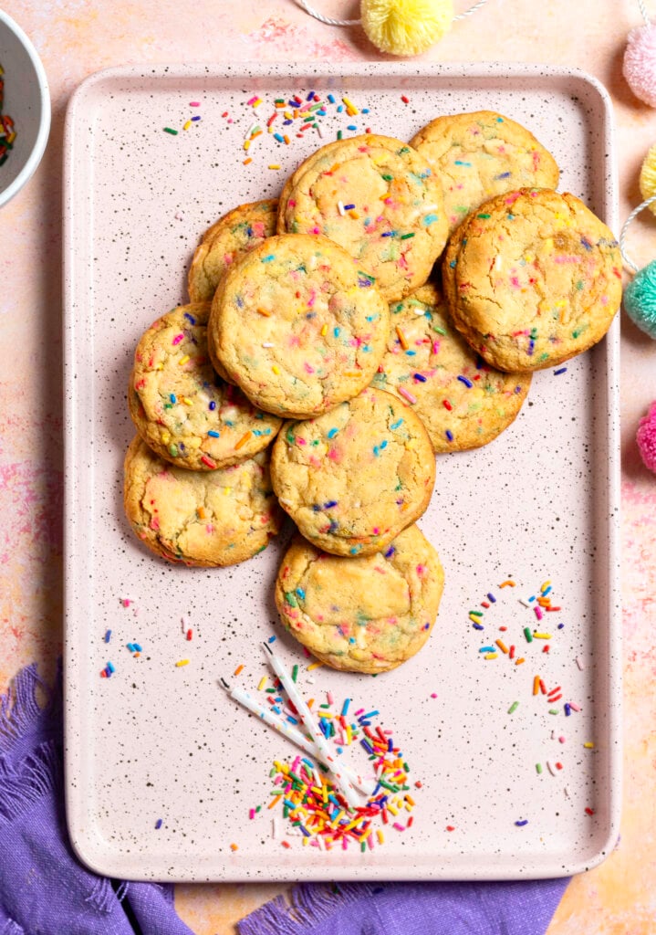 pink baking tray with 10 funfetti birthday cookies, 2 birthday candles and some sprinkles