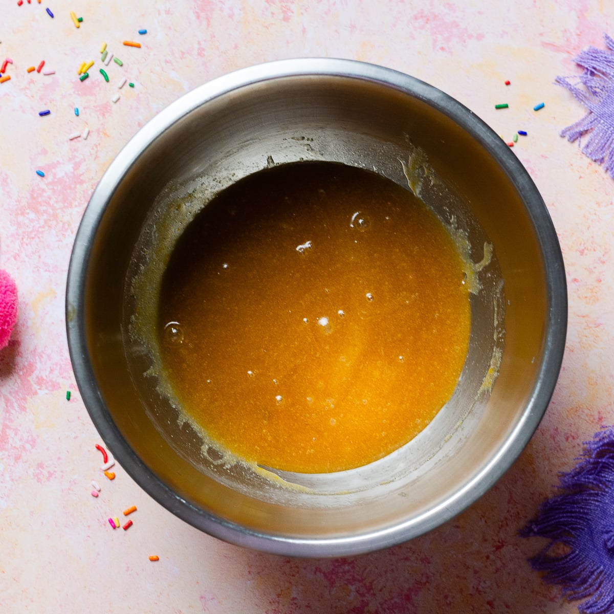 melted butter, sugar and eggs mixed in a bowl.