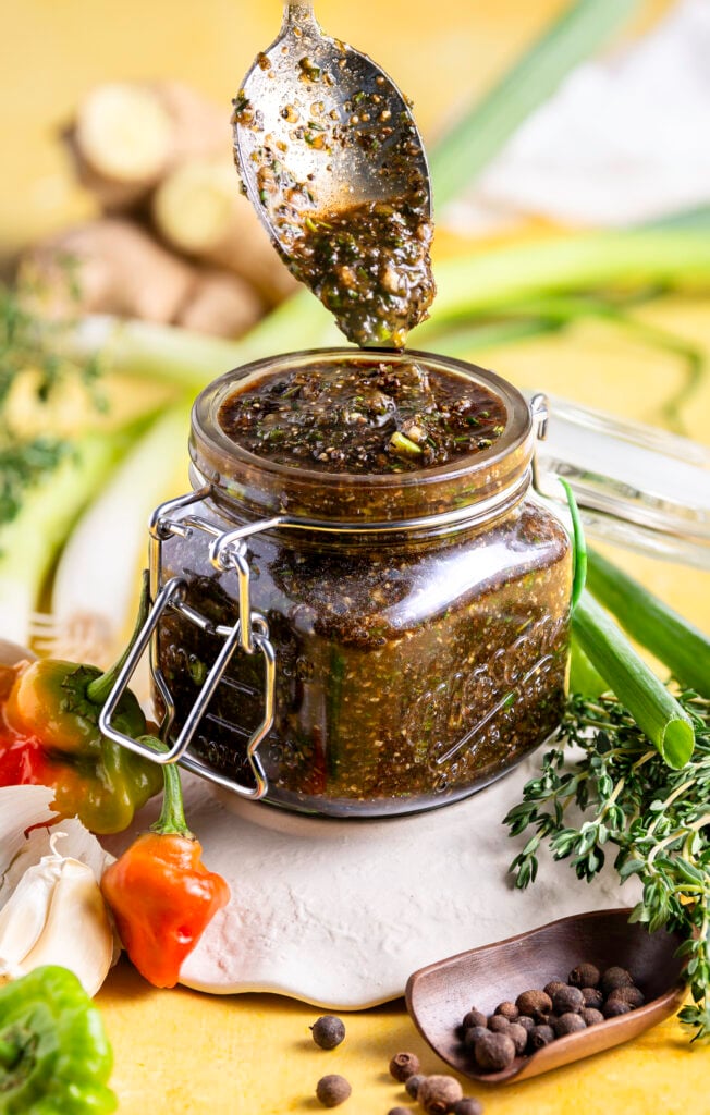 mason jar being filled with authentic jamaican jerk seasoning