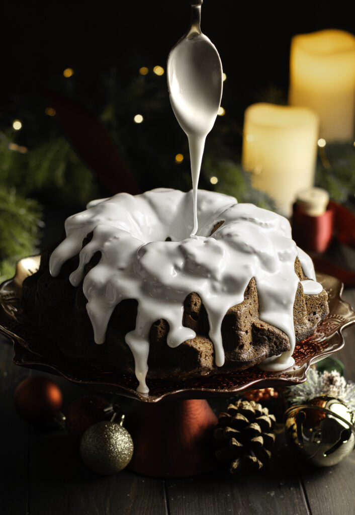 Jamaican black cake being glazed with royal icing 