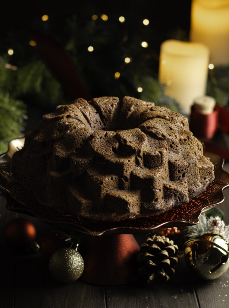 Jamaican black cake made in a Nordic ware blossom bundt pan on a red cake stand