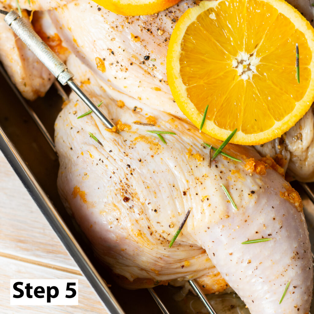 meat thermometer placed in the thigh of a spatchcocked chicken