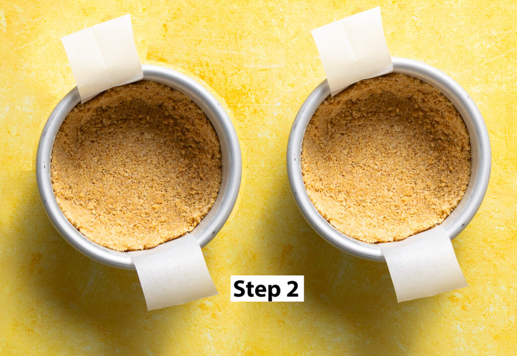 2 cake pans lined with parchment paper and graham cracker crust pressed in