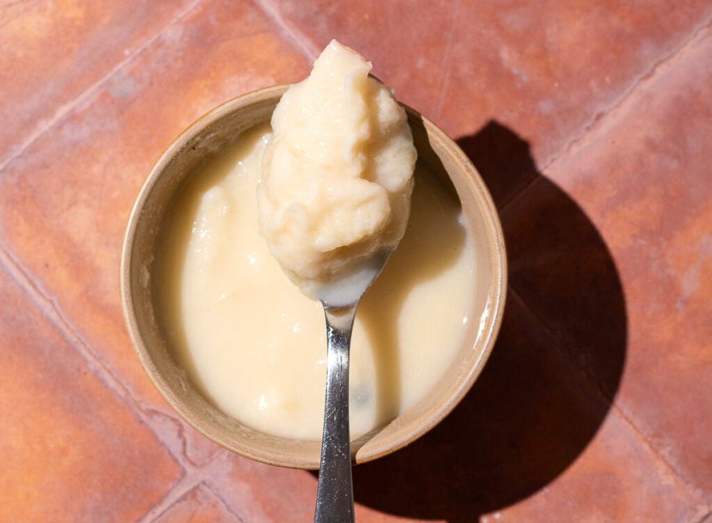 spoon of soursop pulp placed across of a bowl of soursop pulp