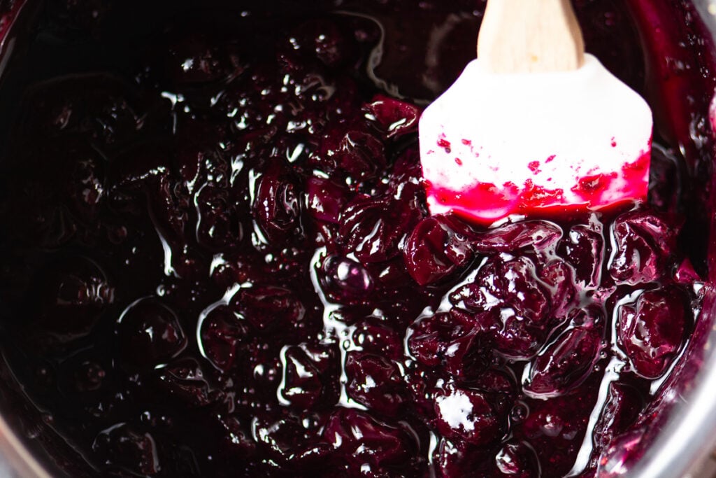 blueberry compote in a saucepan with spatula