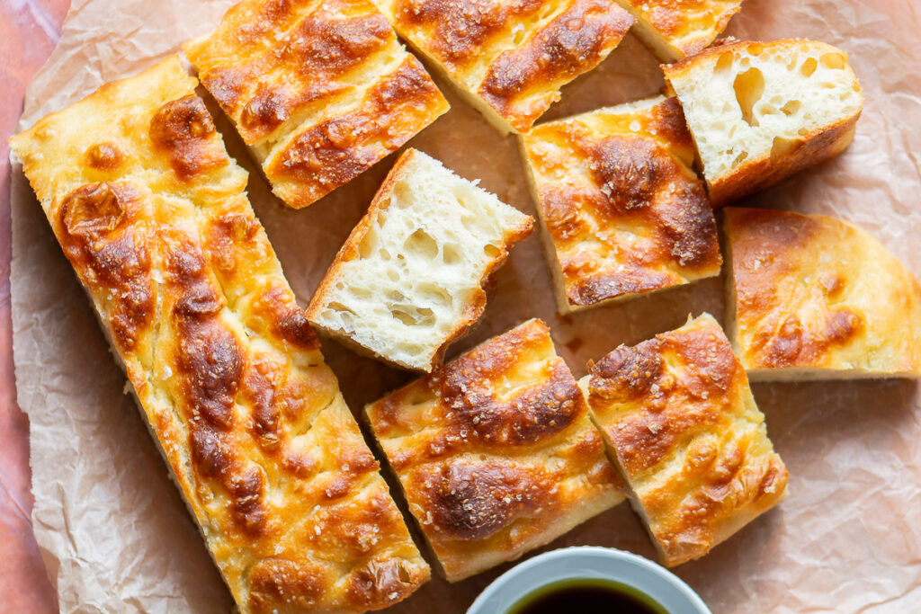 cassava focaccia bread cut into squares on brown parchment paper