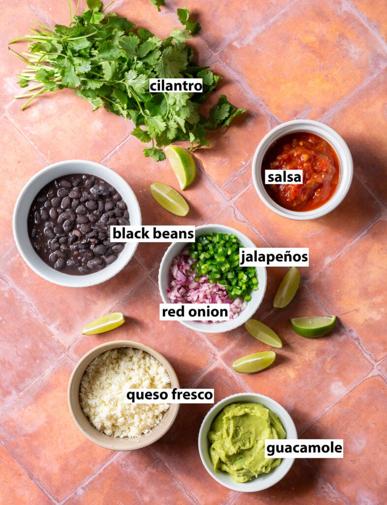 topping ideas for chicken tinga tacos - cilantro, black beans, diced jalapeños, diced red onions, salsa, queso fresco & guacamole