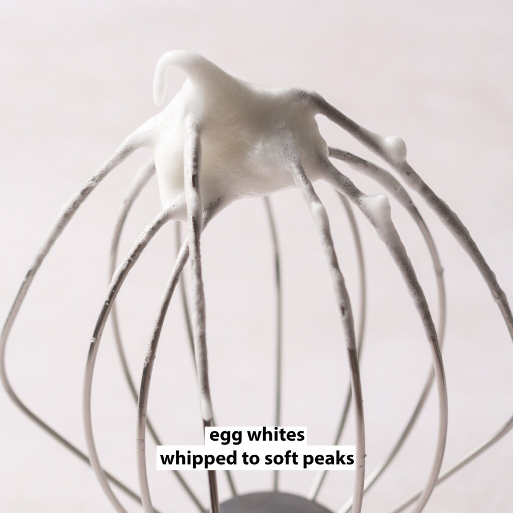 egg whites whipped to soft peaks on a whisk