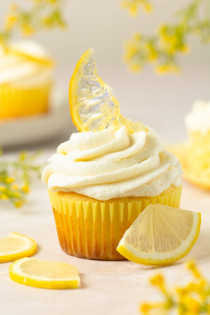 lemon cupcake topped with ermine cream cheese frosting and a candied lemon slice