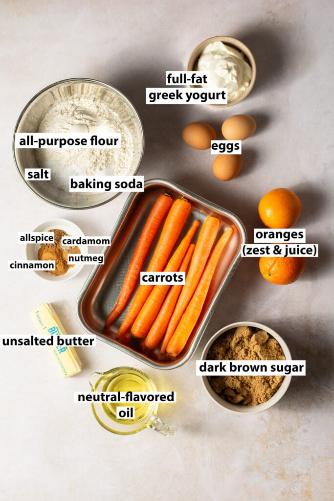 ingredients for carrot bundt cake - carrots, all-purpose flour, oranges, dark brown sugar, butter, oil, eggs, allspice, cardamom, nutmeg, cinnamon, salt, baking soda
