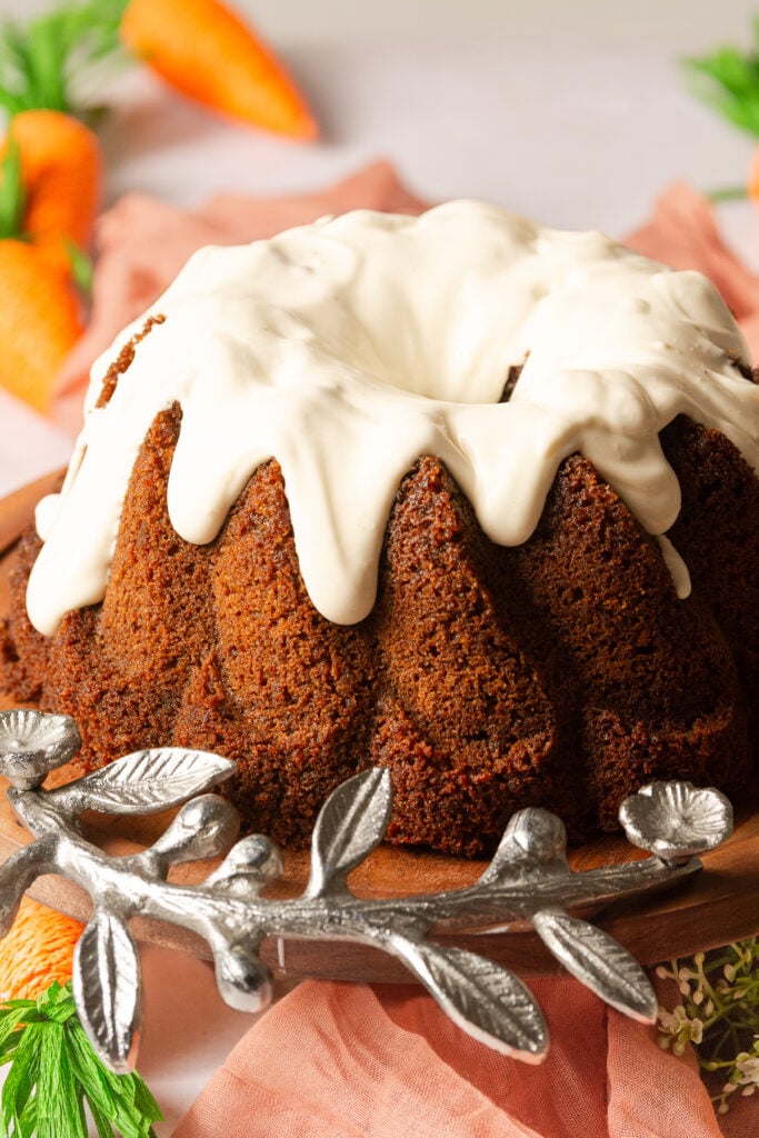 carrot bundt cake with cream cheese glaze on a cake stand