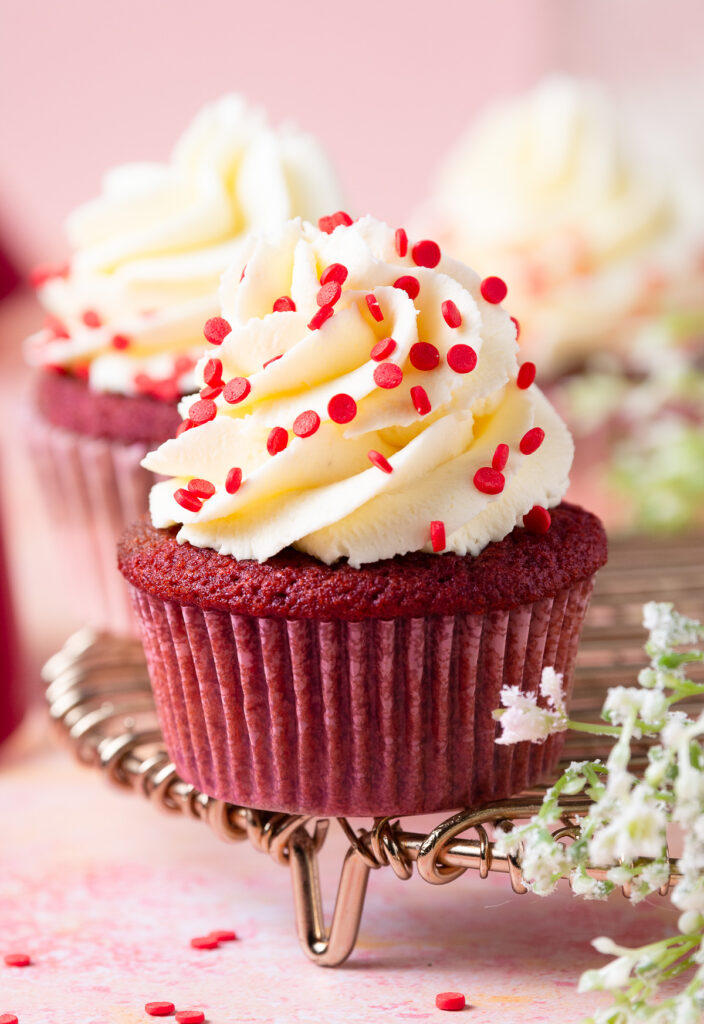 red velvet cupcake with cream cheese frosting on a wire rack