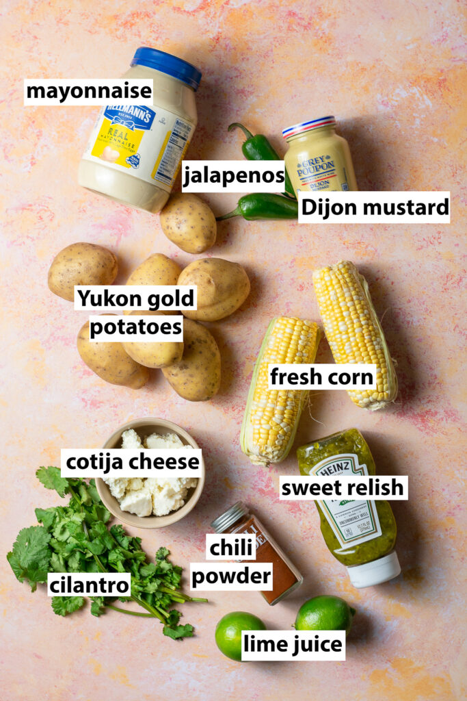 ingredients for Mexican street corn potato salad - Yukon gold potatoes, fresh corn, jalapeños, Dijon mustard, cotija cheese, sweet relish, chili powder, cilantro, mayonnaise, lime juice, cayenne pepper