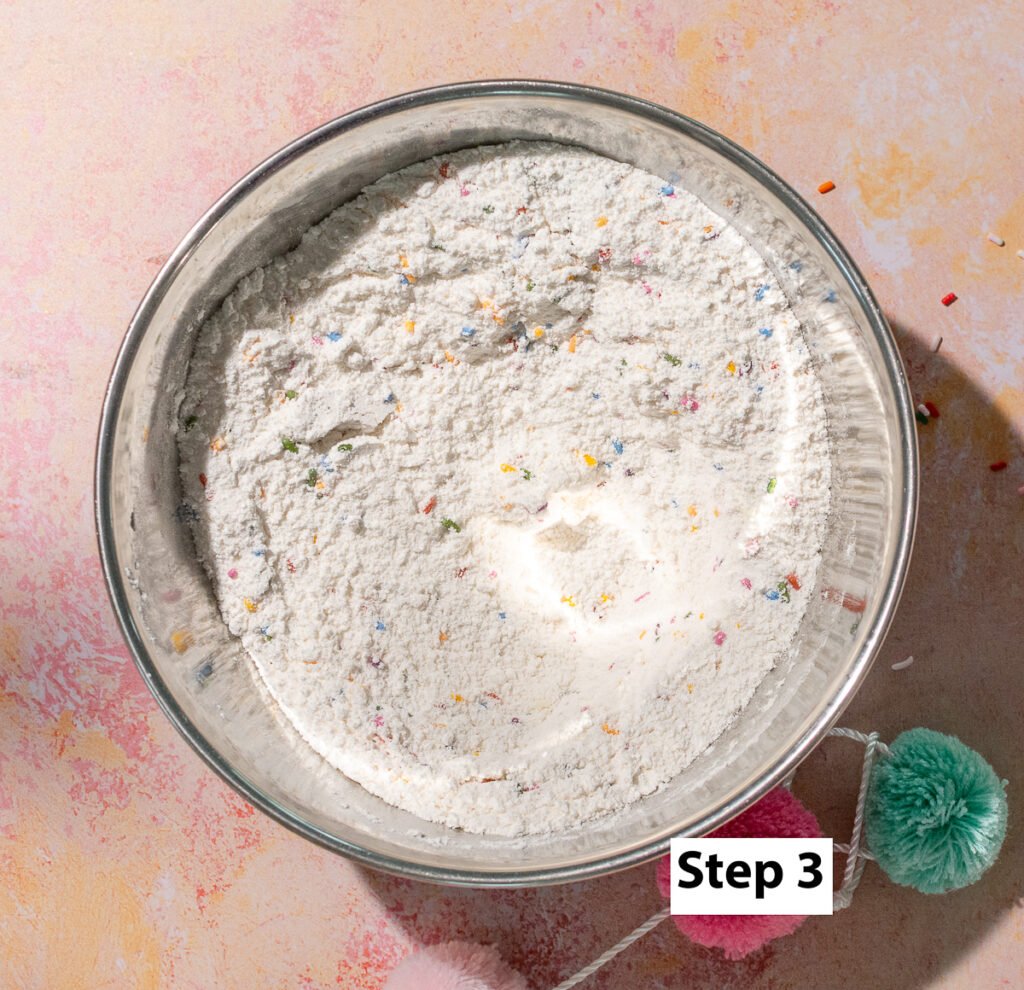dry ingredients mixed in a bowl for a funfetti snack cake