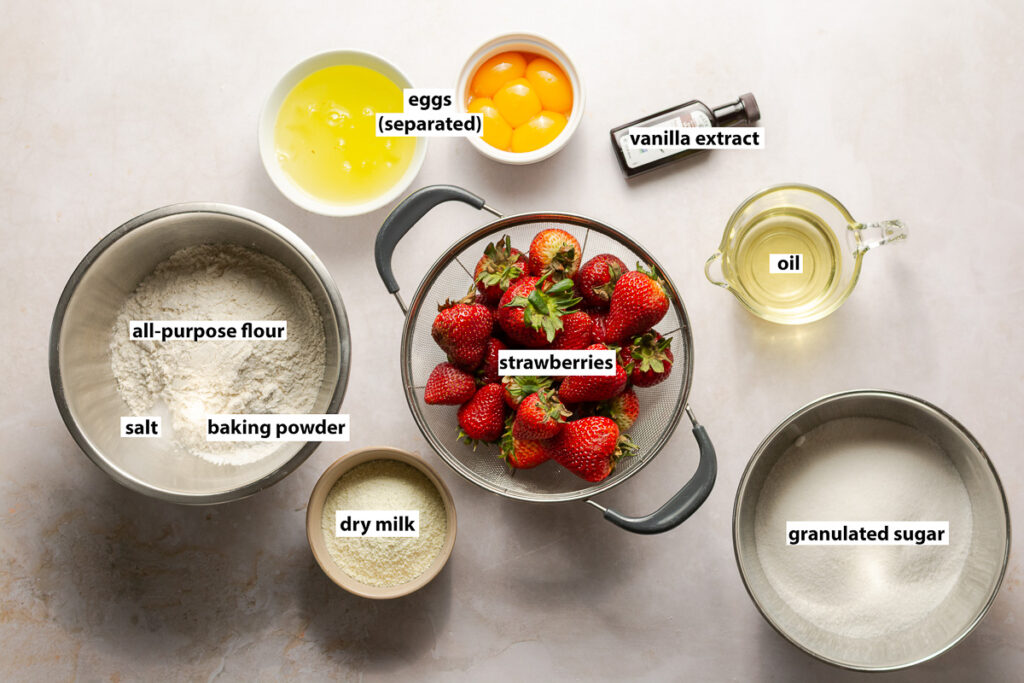 ingredients for strawberry cake layers - strawberries, all-purpose, eggs (separated), vanilla extract, oil, dry milk, granulated sugar, baking powder & salt
