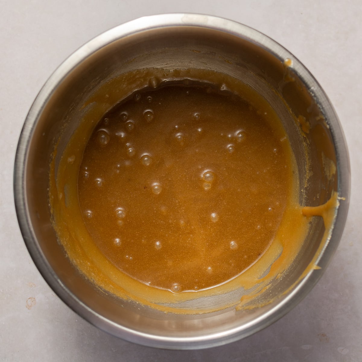 mixture of melted butter, sugar, eggs and vanilla in a mixing bowl.