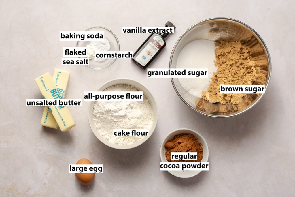 ingredients for chocolate cookies - all-purpose flour, cake flour, granulated sugar, brown sugar, cocoa powder, egg, vanilla extract, unsalted butter, baking soda, flaked sea salt & cornstarch