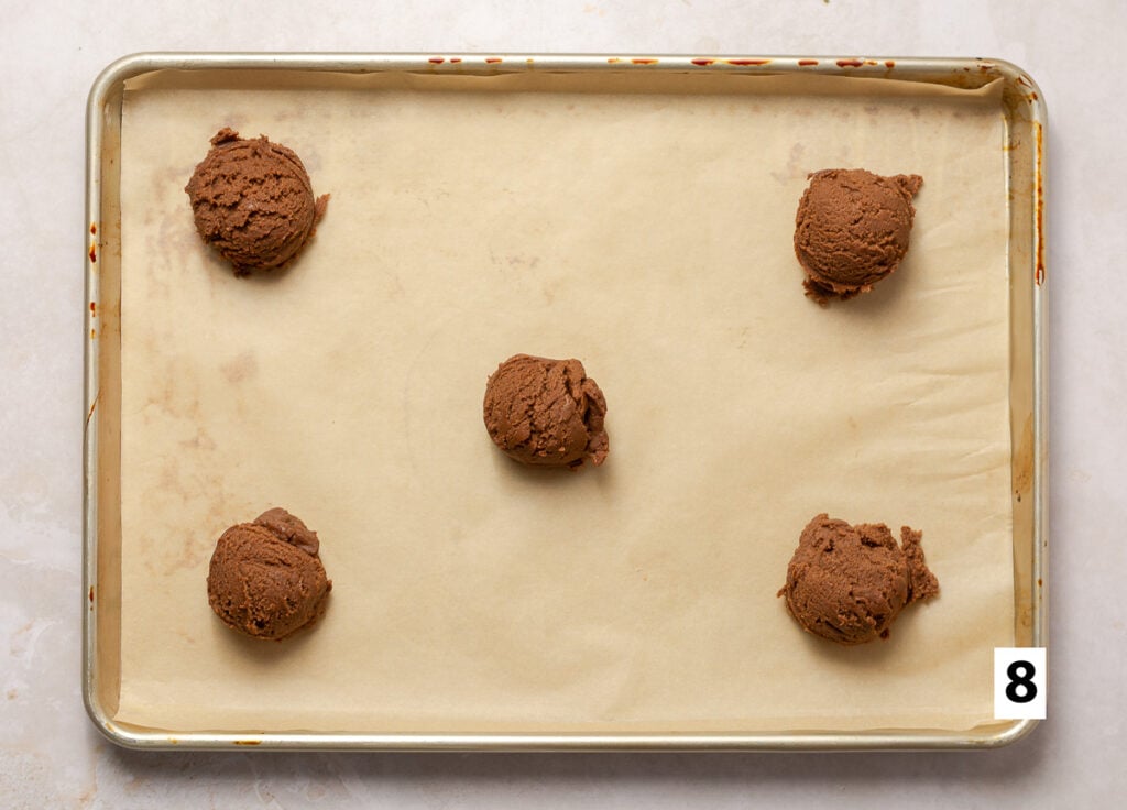 balls of chocolate cookie dough on a parchment-lined baking sheet