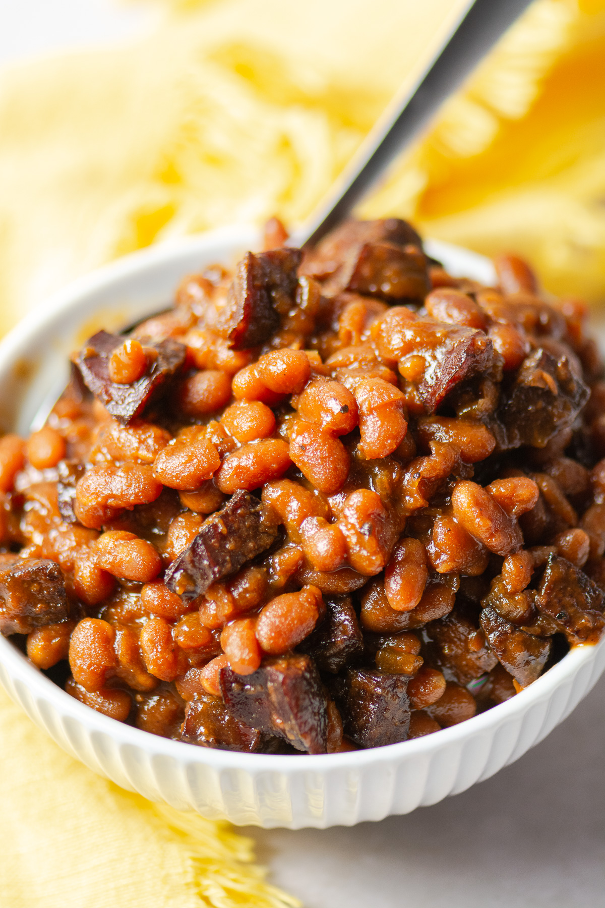 maple barbecue baked beans in a bowl with a spoon
