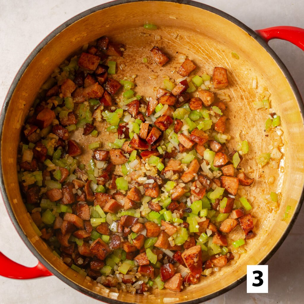 dutch oven with sautéed kielbasa, celery and yellow onions