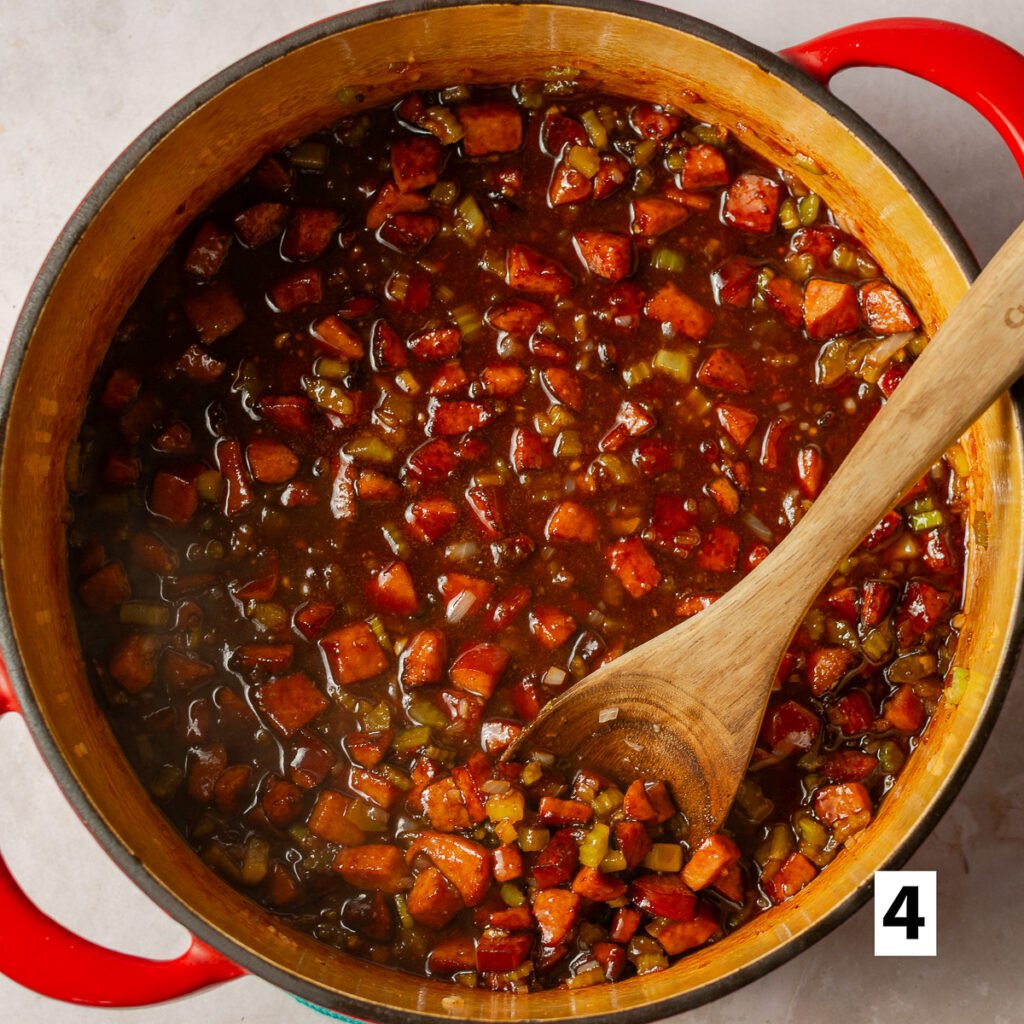 kielbasa with vegetables and barbecue sauce in a dutch oven