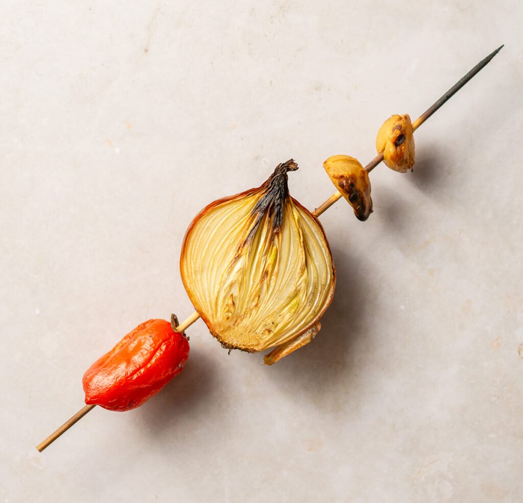habanero pepper, yellow onion & garlic cloves on a skewer