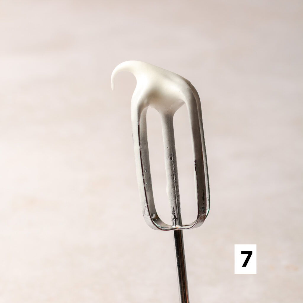 egg whites whipped to soft peaks on a whisk
