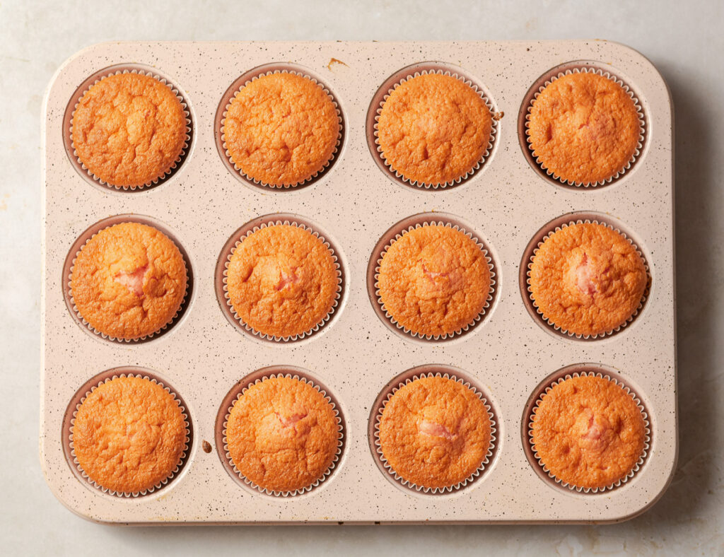 baked strawberry cupcakes in a standard 12-muffin pan