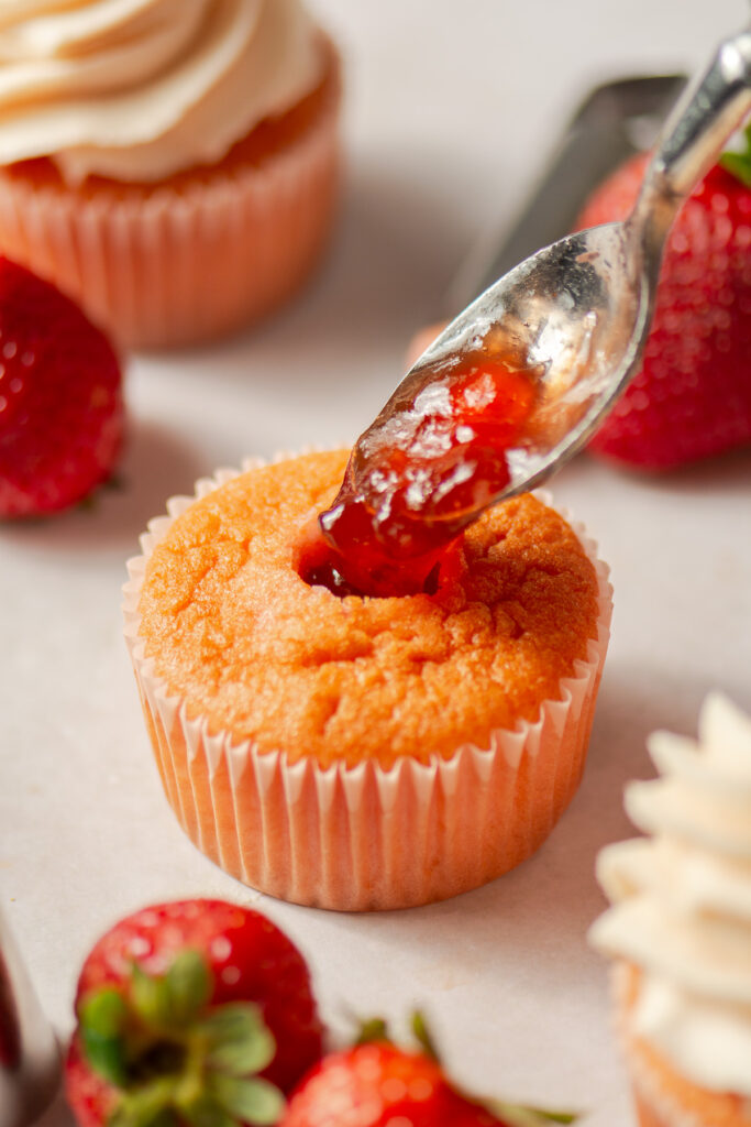 filling strawberry cupcakes with strawberry presevres