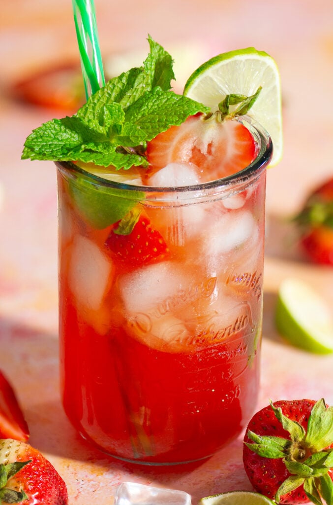 glass of strawberry limeade with a lime slice and mint garnish