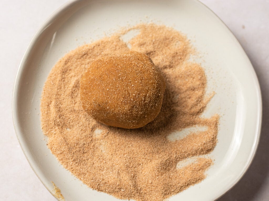 ball of banana snickerdoodle dough rolled in cinnamon sugar topping