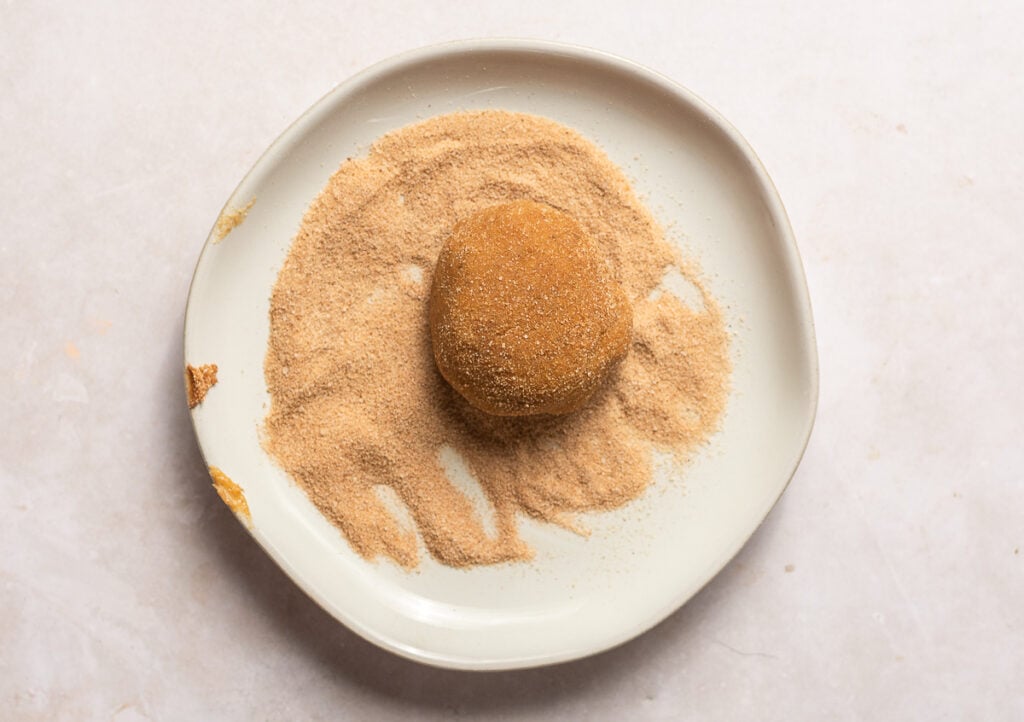 ball of banana snickerdoodle dough rolled in cinnamon sugar topping