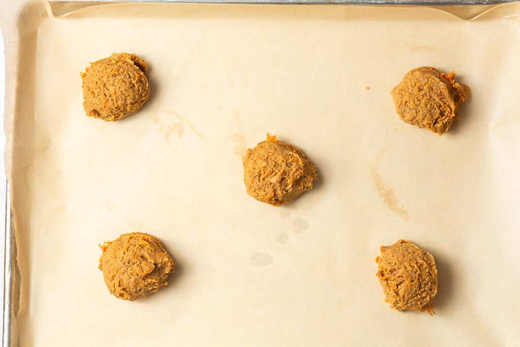 carrot cake cookie dough on a parchment-lined baking sheet