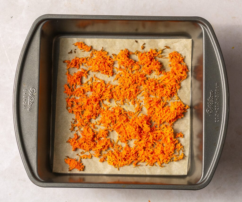 grated roasted carrots in a parchment lined baking pan