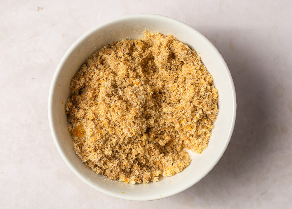 orange zest rubbed into brown and granulated sugar in a bowl