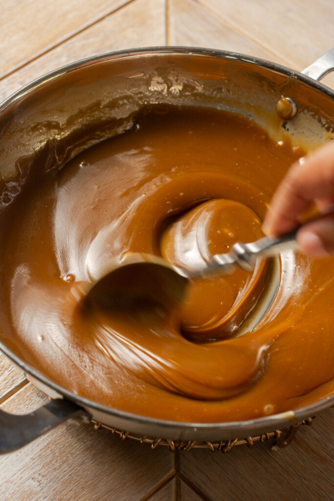 butterscotch being stirred in stainless steel pan