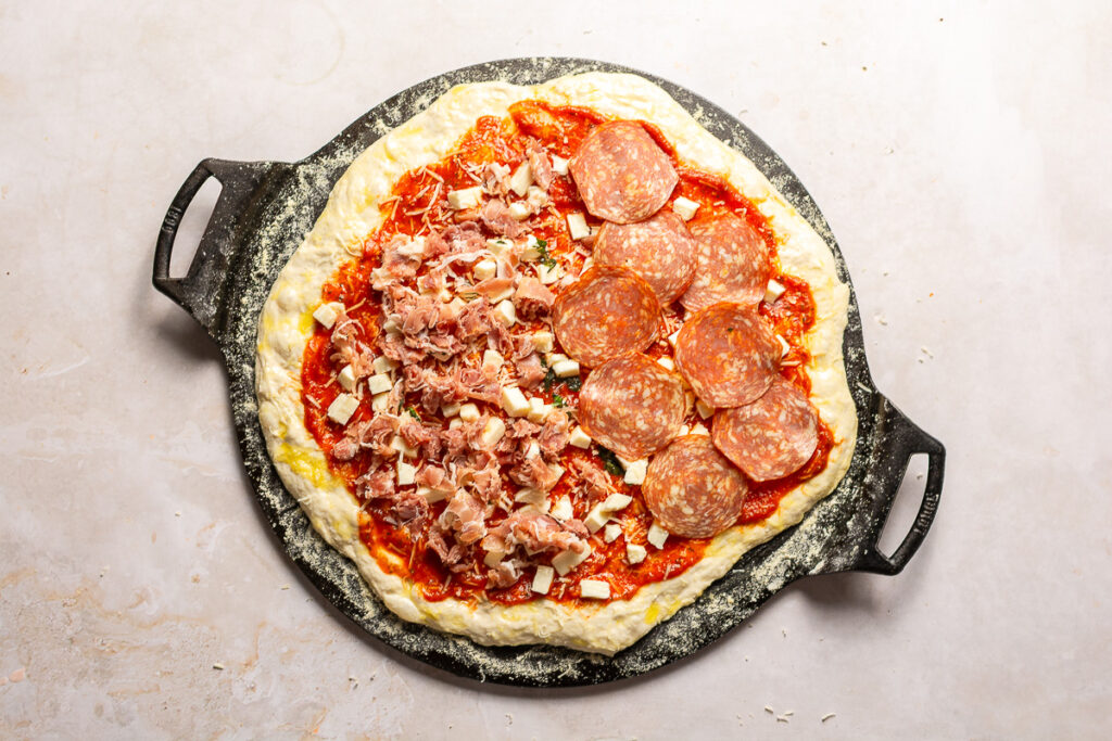unbaked pizza with homemade pizza dough on a cast iron griddle