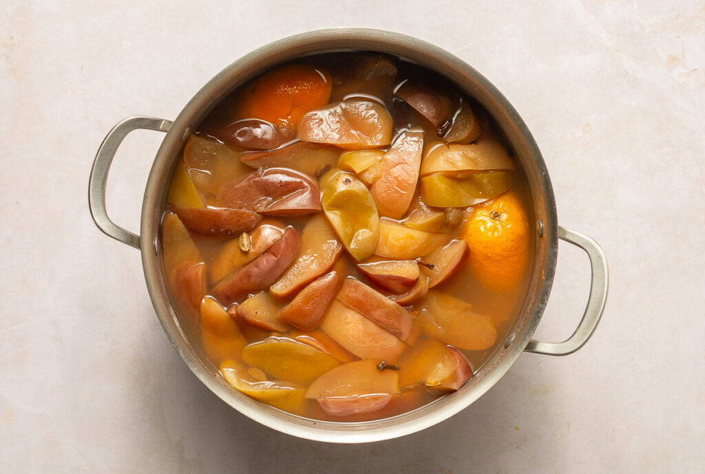 stockpot with simmered apples, oranges, chamomile tea, cinnamon sticks, cardamom pods & whole cloves
