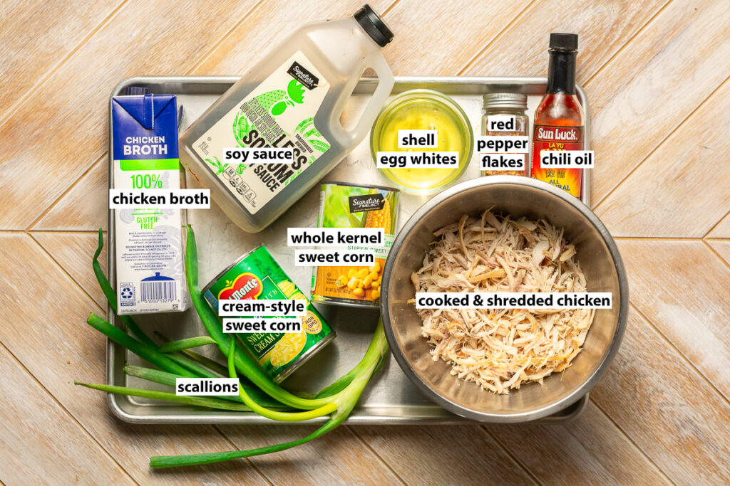 ingredients for Chinese chicken and sweet corn soup - cooked & shredded chicken, whole kernel sweet corn, cream-style sweet corn, soy sauce, chicken broth, egg whites, red pepper flakes, chili oil, scallions