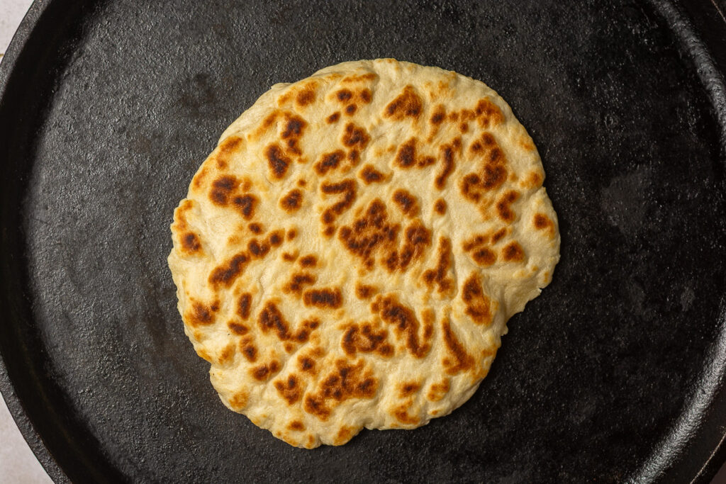 cooked Belizean flour tortilla on a hot comal