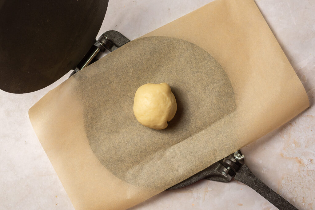 ball of dough on a tortilla press
