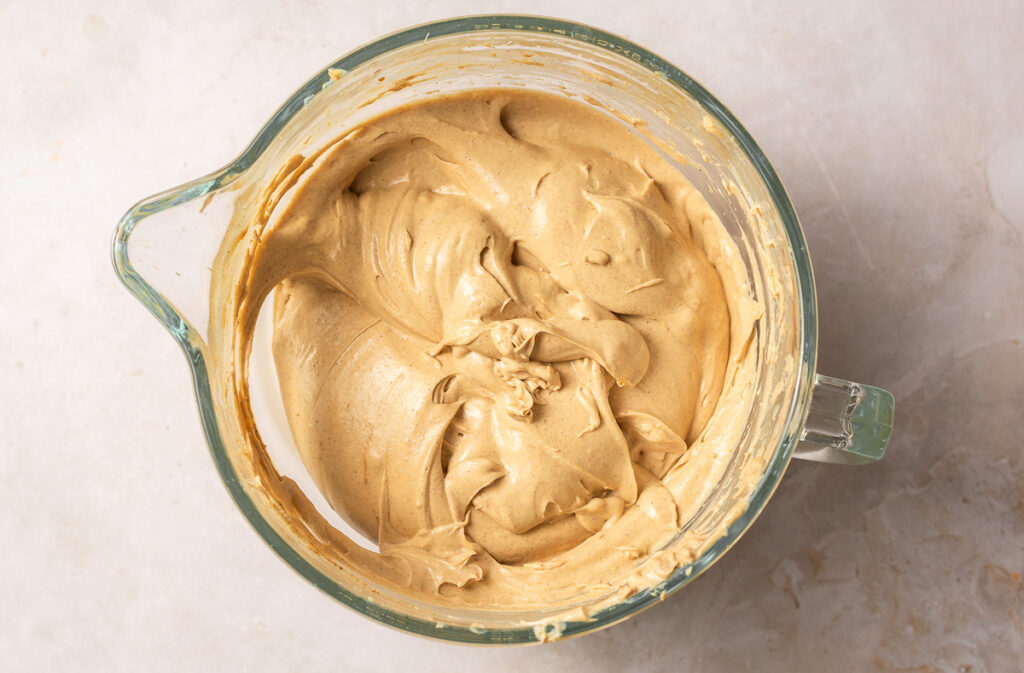 creamed cream cheese, brown sugar, sour cream, ground ginger and ground cinnamon in a bowl.