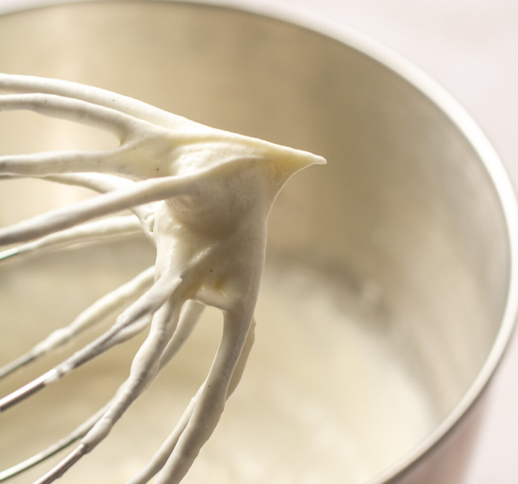 heavy cream whipped to soft peaks on a whisk