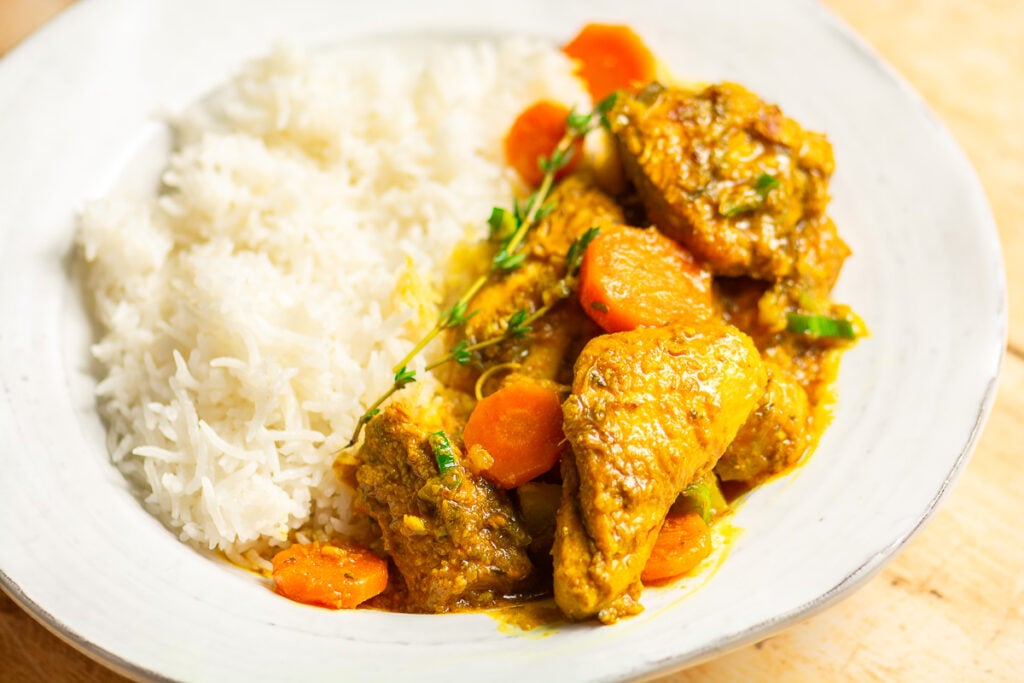 Jamaican curry chicken with white rice in a bowl