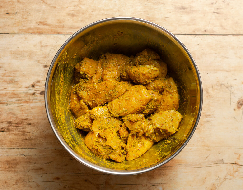 bone-in, skinless chicken cut into chunks and marinated in green seasoning and curry powder