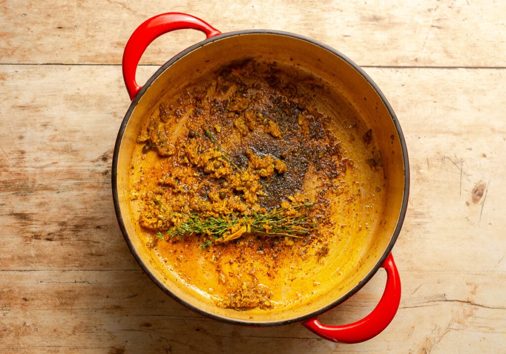 fond in the bottom of a dutch oven with a thyme bouquet